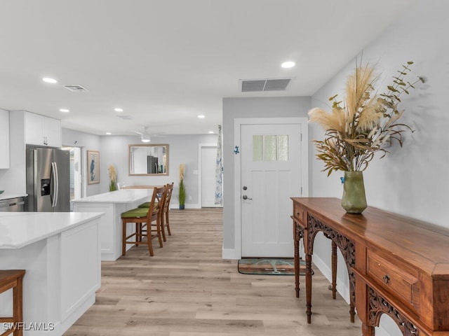 foyer with ceiling fan and light hardwood / wood-style floors