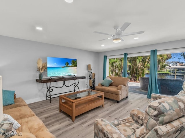 living room featuring ceiling fan and light hardwood / wood-style flooring