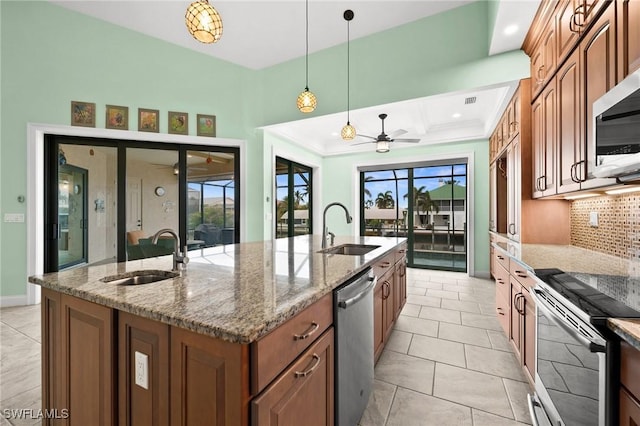 kitchen featuring hanging light fixtures, a center island with sink, stainless steel appliances, and sink