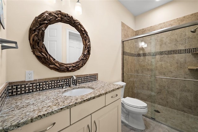 bathroom with vanity, toilet, walk in shower, and backsplash