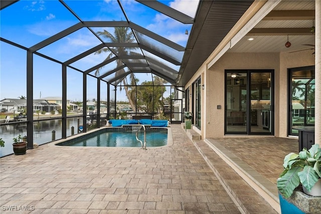 view of pool featuring a lanai, a patio area, and a water view