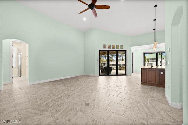 2405 Cherimoya Ln, Saint James City, FL 33956 - unfurnished living room featuring a ceiling fan, high vaulted ceiling, and arched walkways
