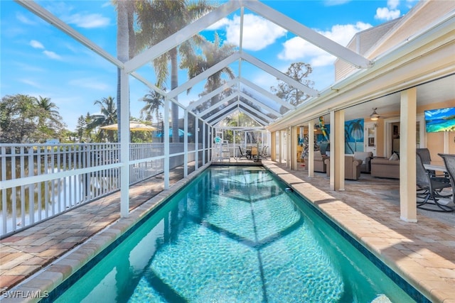 view of pool featuring a lanai, outdoor lounge area, a patio area, and ceiling fan