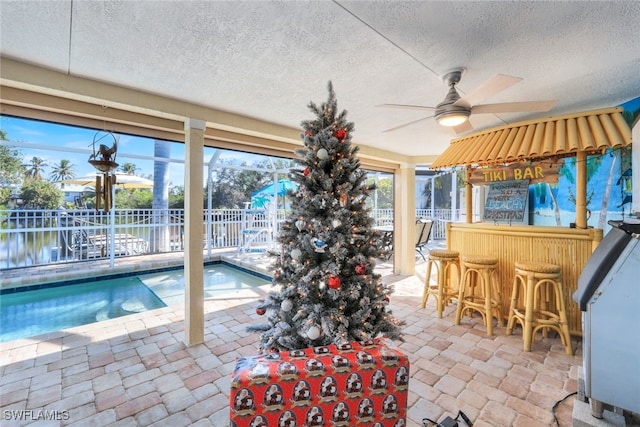 view of pool featuring ceiling fan and a water view