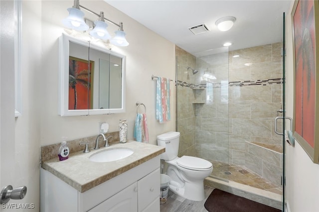 bathroom with toilet, vanity, an enclosed shower, and hardwood / wood-style flooring