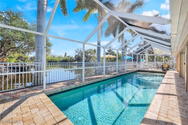 view of swimming pool featuring a lanai, a water view, and a patio