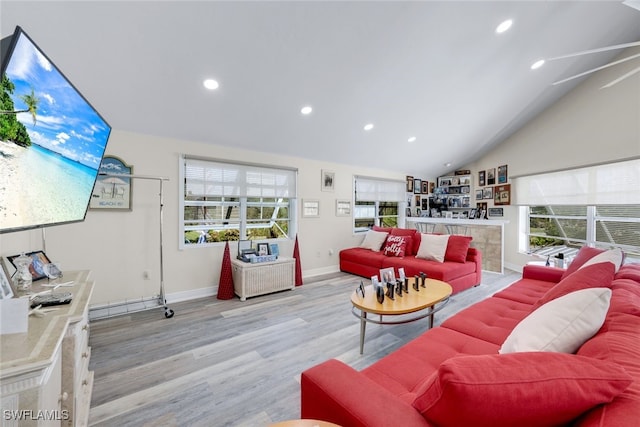 living room featuring light hardwood / wood-style floors, vaulted ceiling, and plenty of natural light