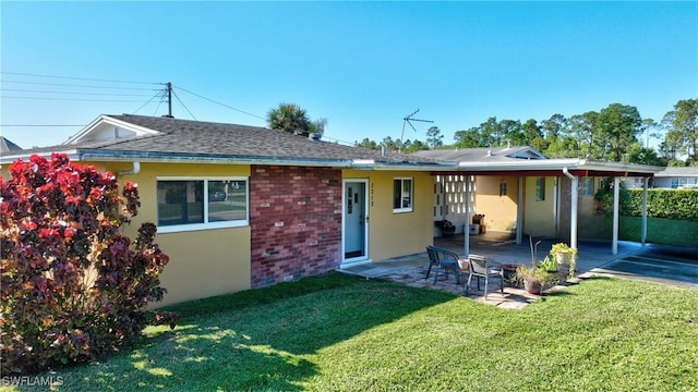 back of property with a yard and a patio