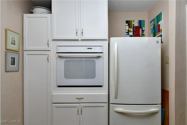 kitchen featuring white cabinets and white appliances