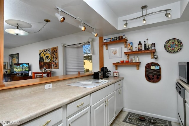 kitchen featuring white cabinets, rail lighting, and white electric cooktop