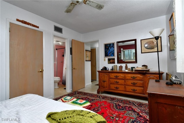 bedroom featuring ensuite bath, ceiling fan, and a textured ceiling