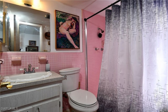 bathroom featuring walk in shower, vanity, toilet, and tile walls