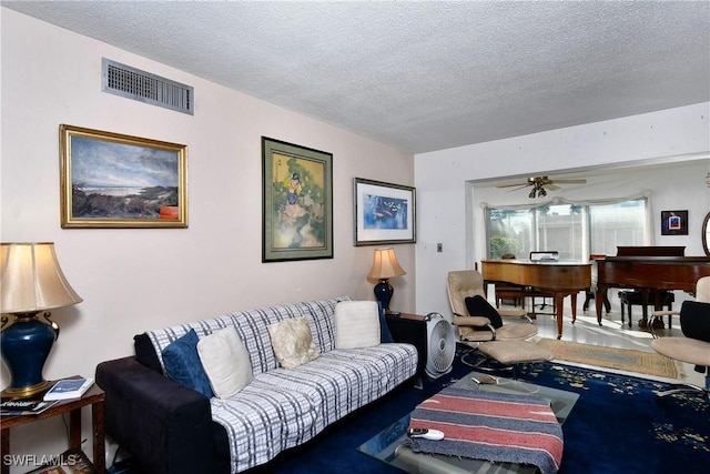 living room featuring ceiling fan and a textured ceiling