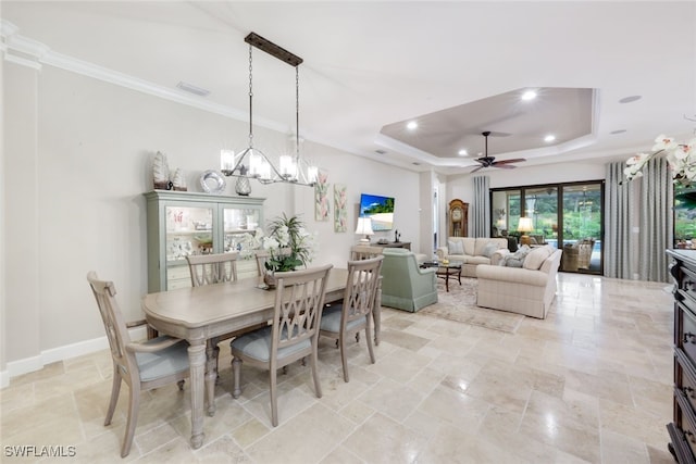 dining room with ceiling fan with notable chandelier, ornamental molding, and a tray ceiling