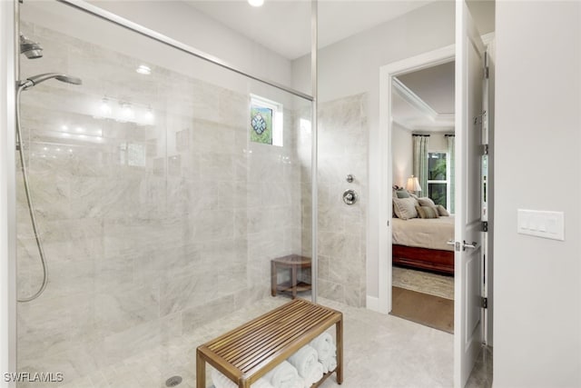 bathroom with a healthy amount of sunlight, ornamental molding, and tiled shower