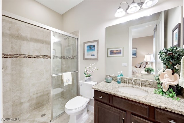 bathroom featuring vanity, toilet, and a shower with door