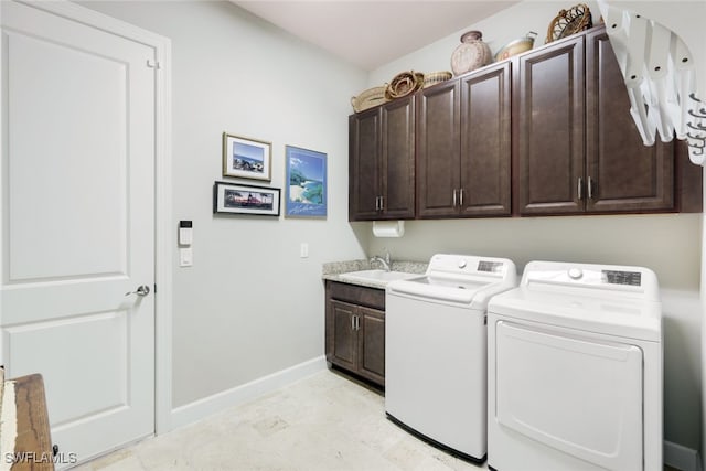 washroom with washing machine and dryer, sink, and cabinets