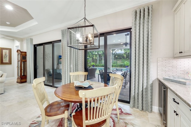 dining area with ornamental molding, wine cooler, and an inviting chandelier