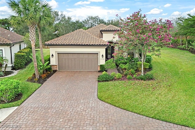 mediterranean / spanish-style home featuring a front yard and a garage