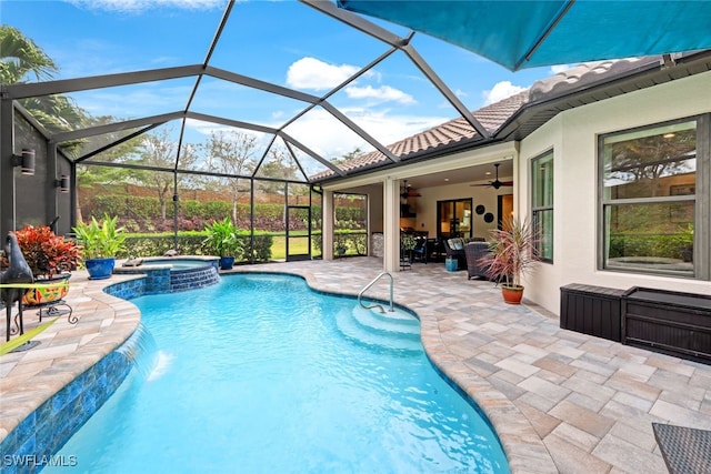 view of swimming pool featuring ceiling fan, glass enclosure, an in ground hot tub, and a patio