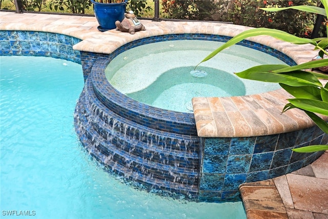 view of swimming pool with an in ground hot tub