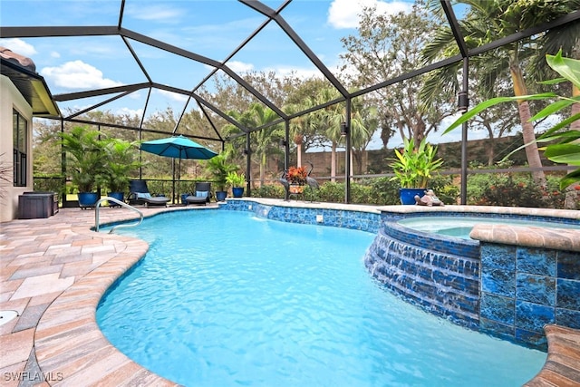 view of pool with pool water feature, glass enclosure, a patio area, and an in ground hot tub