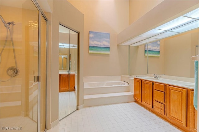 bathroom with plus walk in shower, vanity, and tile patterned flooring