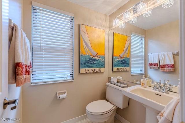 bathroom featuring sink, tile patterned flooring, a healthy amount of sunlight, and toilet