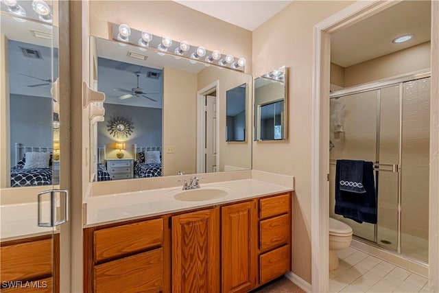 bathroom with tile patterned floors, vanity, toilet, and walk in shower