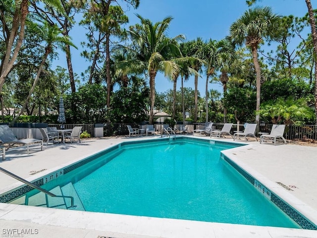 27062 Kindlewood Ln, Bonita Springs, FL 34134 - community pool featuring a patio area and view of wooded area
