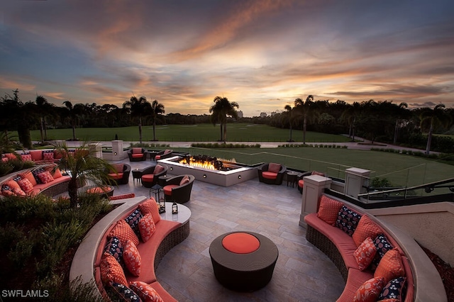 patio terrace at dusk with an outdoor living space with a fire pit