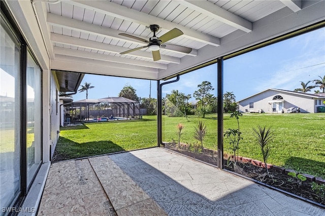 unfurnished sunroom with beamed ceiling and ceiling fan