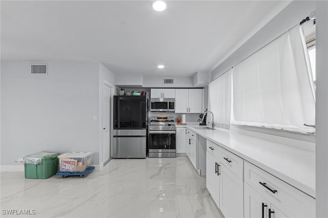 kitchen featuring stainless steel appliances, white cabinetry, and sink