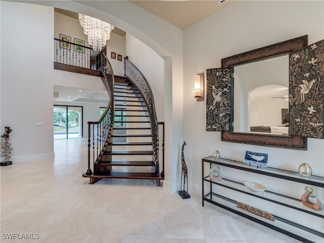 stairway featuring baseboards and a notable chandelier