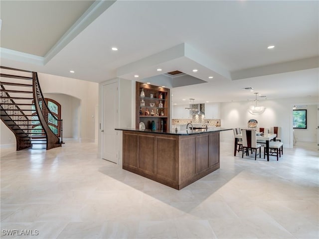 bar with arched walkways, recessed lighting, stairs, wall chimney range hood, and tasteful backsplash