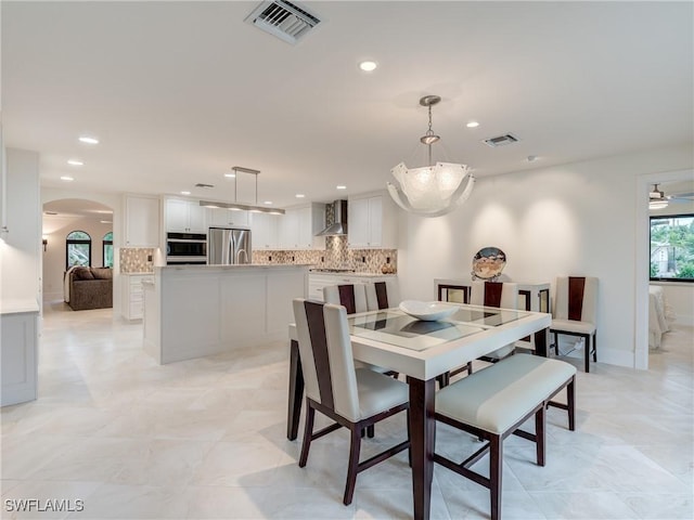 dining room with arched walkways, visible vents, and recessed lighting