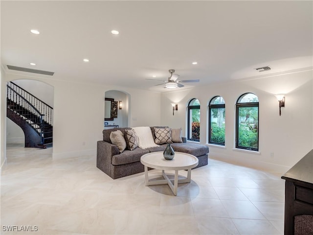 living room featuring arched walkways, recessed lighting, visible vents, ceiling fan, and stairs