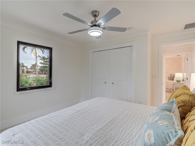 bedroom featuring ornamental molding, a closet, visible vents, and a ceiling fan