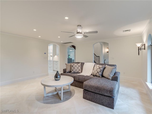 living area featuring arched walkways, recessed lighting, visible vents, ornamental molding, and baseboards