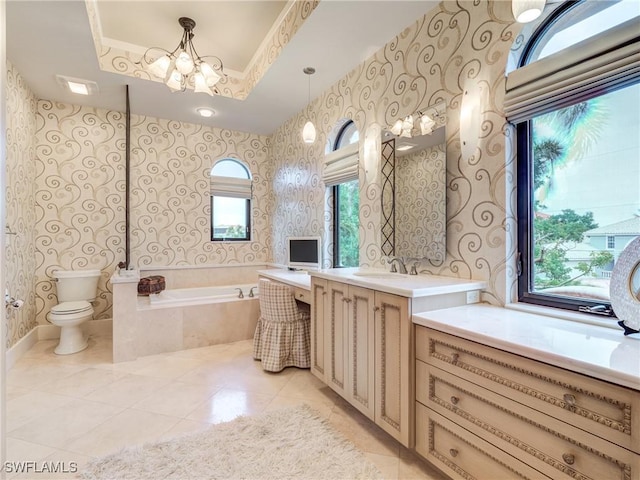 full bath featuring toilet, a garden tub, vanity, and wallpapered walls