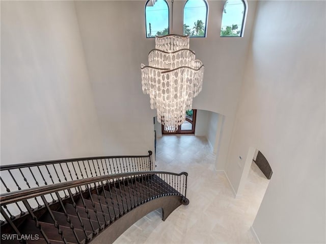 staircase with baseboards and an inviting chandelier