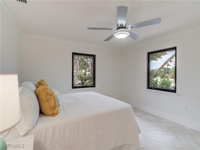 bedroom featuring ceiling fan, crown molding, and baseboards