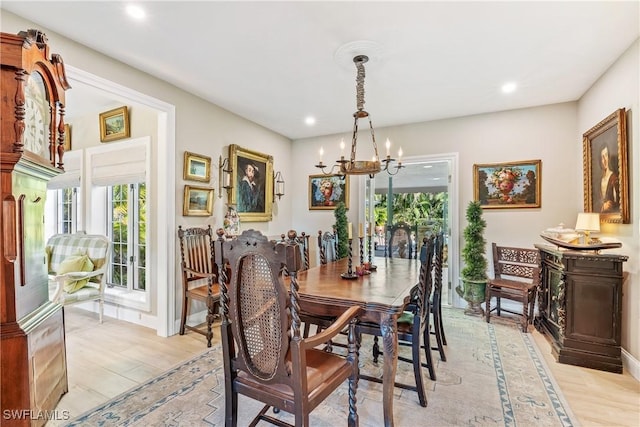 dining area with an inviting chandelier and light hardwood / wood-style floors