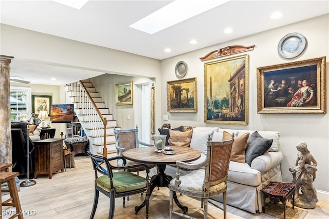 dining room featuring a skylight and light hardwood / wood-style flooring