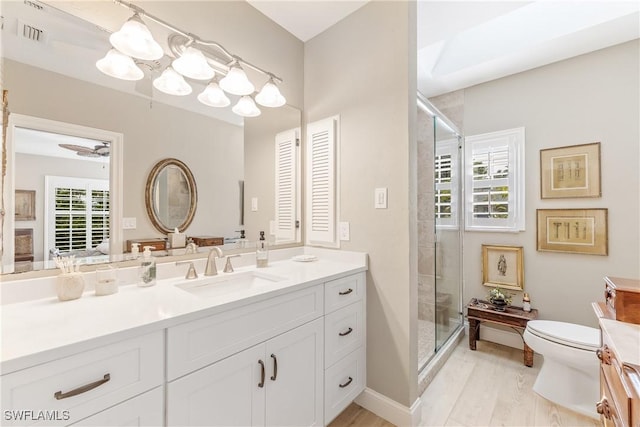 bathroom with ceiling fan, vanity, plenty of natural light, and walk in shower