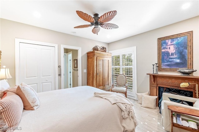 bedroom with ceiling fan, light hardwood / wood-style floors, and a closet