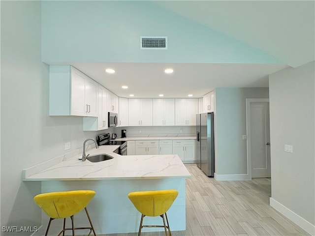 6342 Royal Woods Dr, Fort Myers, FL 33908 - kitchen with a sink, a breakfast bar, appliances with stainless steel finishes, a peninsula, and visible vents