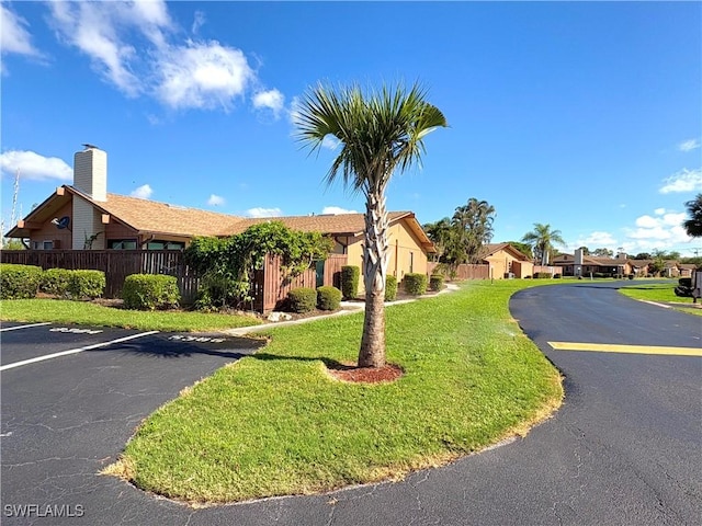 6342 Royal Woods Dr, Fort Myers, FL 33908 - view of building exterior with fence, uncovered parking, and a residential view