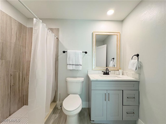 bathroom with curtained shower, vanity, hardwood / wood-style flooring, and toilet