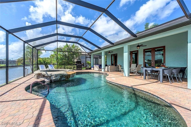 view of swimming pool with glass enclosure, french doors, a water view, ceiling fan, and a patio area